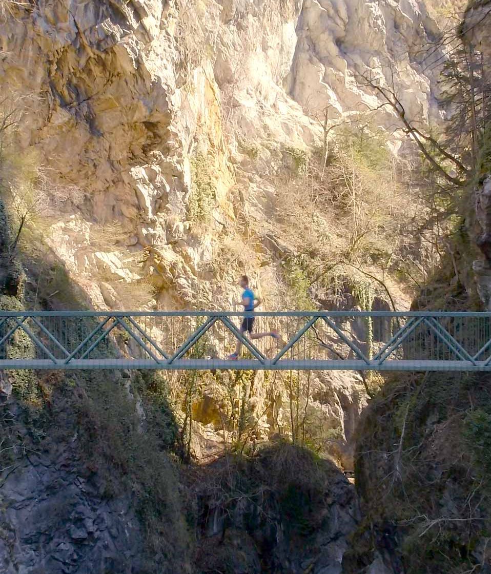 Vue par drone d'un coureur sur un pont en montagne